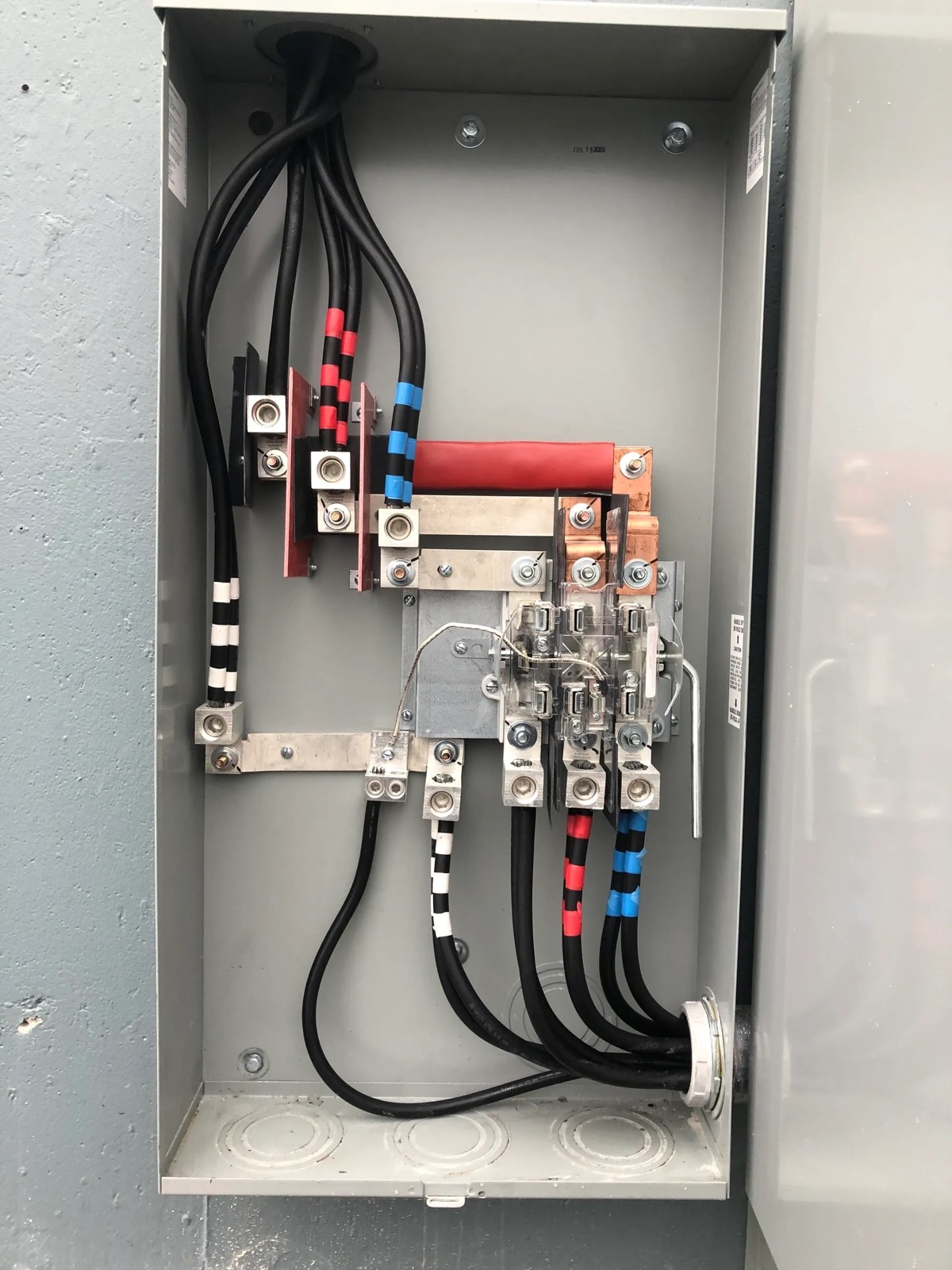 Phase-taped conductors landed on distribution lugs in a commercial panel