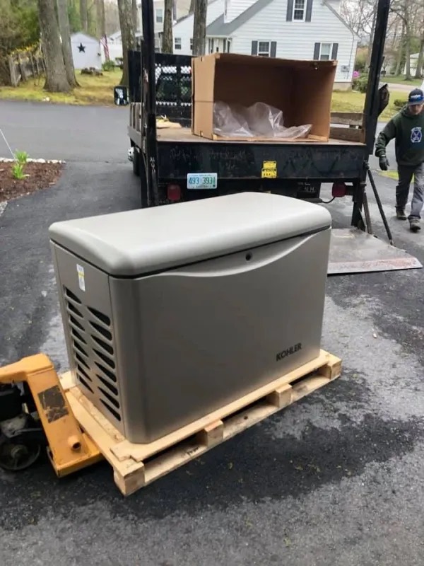 A Kohler standby generator on a pallet being unloaded from the truck at a job