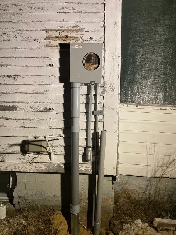 Meter socket and service conduit on a clapboard house